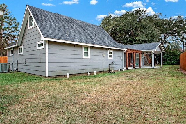 rear view of property featuring a lawn, cooling unit, and a patio area