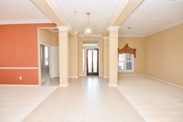 carpeted entrance foyer featuring ornate columns, crown molding, and an inviting chandelier