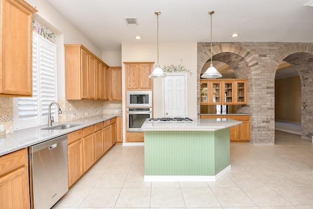 kitchen featuring backsplash, a kitchen island, sink, and stainless steel appliances