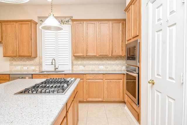 kitchen featuring hanging light fixtures, sink, decorative backsplash, light tile patterned floors, and appliances with stainless steel finishes