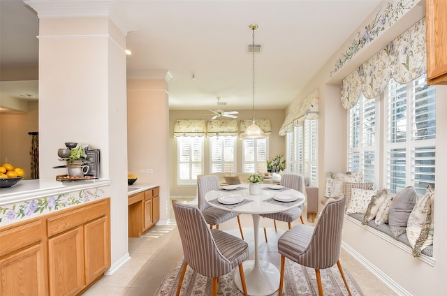 tiled dining room with ceiling fan and ornamental molding