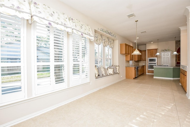 kitchen with backsplash, hanging light fixtures, light tile patterned floors, and stainless steel appliances