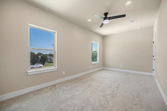 carpeted spare room featuring ceiling fan