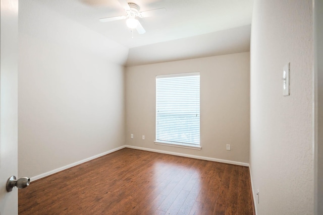 empty room featuring vaulted ceiling, a wealth of natural light, ceiling fan, and dark hardwood / wood-style floors