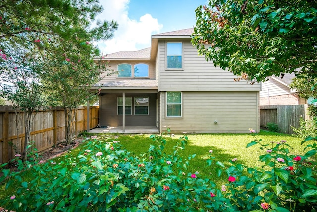 rear view of house featuring a patio area and a yard