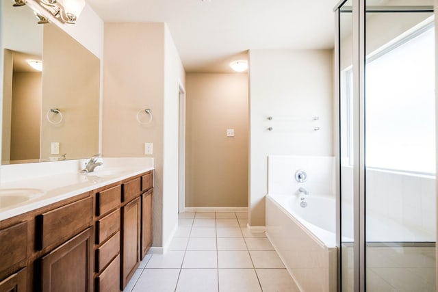 bathroom with tile patterned flooring, vanity, and tiled bath