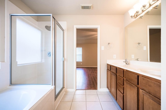 bathroom with tile patterned flooring, vanity, and shower with separate bathtub