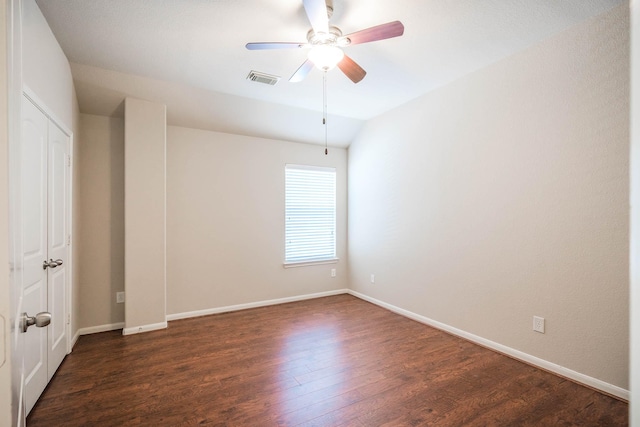 spare room with ceiling fan, lofted ceiling, and dark wood-type flooring