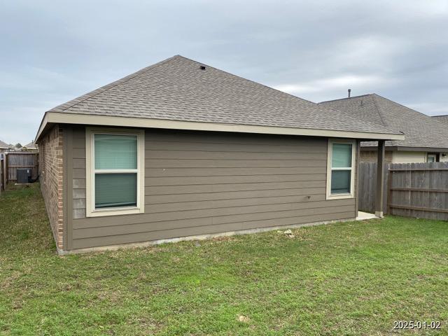 exterior space with a lawn and central AC