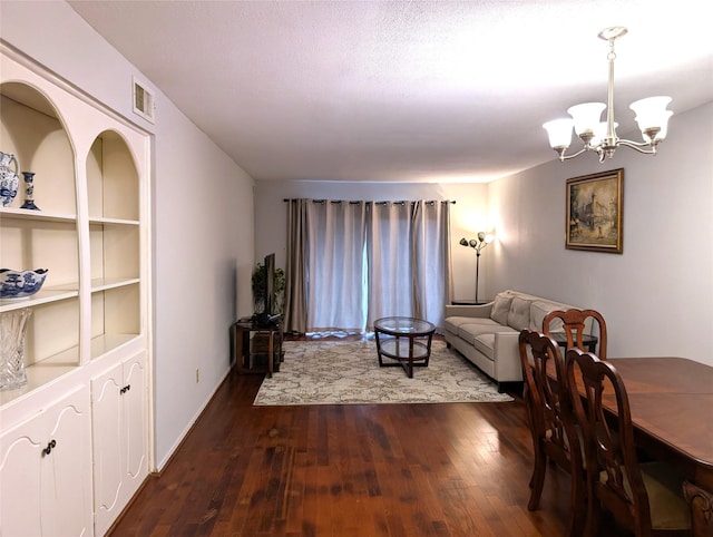 living room featuring a notable chandelier, dark hardwood / wood-style flooring, and built in features