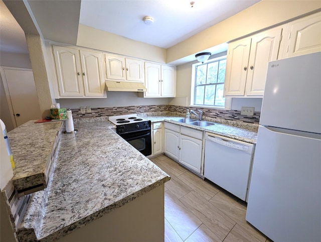 kitchen featuring kitchen peninsula, light stone counters, white appliances, sink, and white cabinets