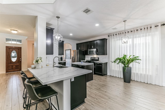 kitchen featuring pendant lighting, kitchen peninsula, sink, and appliances with stainless steel finishes