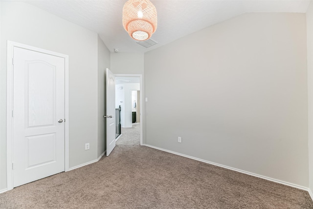 unfurnished room featuring carpet, a textured ceiling, and lofted ceiling