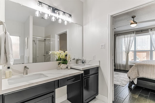 bathroom featuring ceiling fan, a shower with door, and vanity