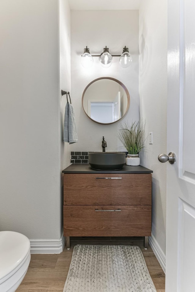 bathroom featuring vanity, hardwood / wood-style flooring, and toilet