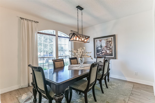 dining room featuring a textured ceiling and light hardwood / wood-style floors