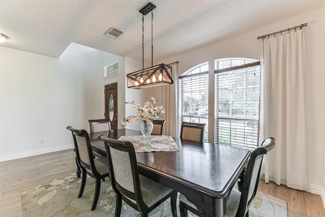 dining room featuring a textured ceiling and light hardwood / wood-style flooring