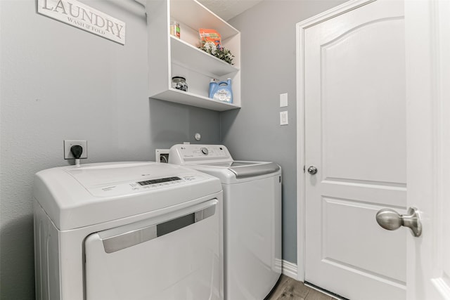 laundry room with separate washer and dryer and light hardwood / wood-style flooring