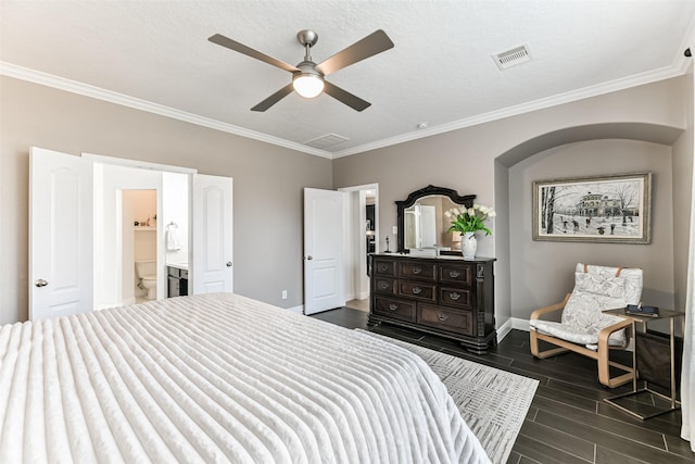 bedroom featuring ceiling fan, crown molding, and ensuite bath