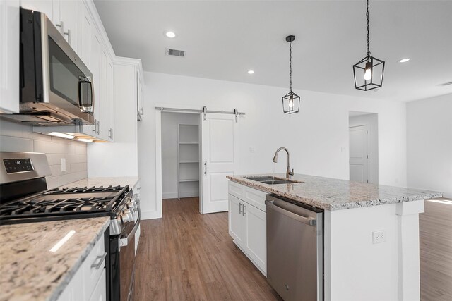 745 20th St, Hempstead, TX 77445 - kitchen with stainless steel appliances, white cabinetry, a center island with sink, and sink