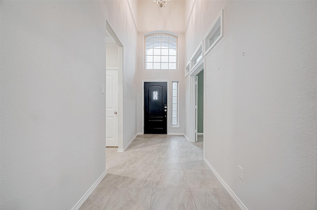 entryway featuring a towering ceiling and an inviting chandelier