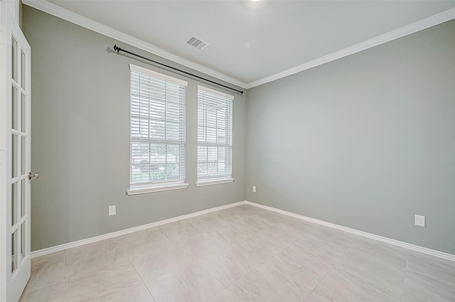 empty room with light tile patterned floors, crown molding, and french doors