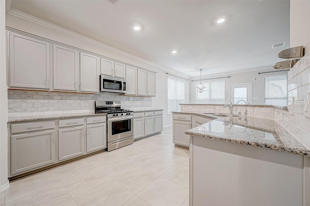 kitchen with pendant lighting, sink, stainless steel appliances, and ornamental molding