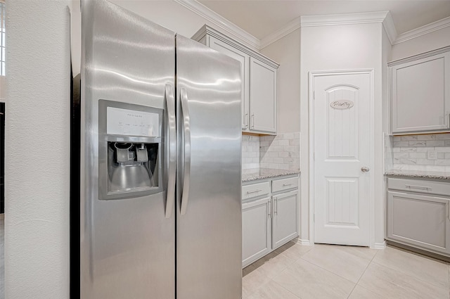 kitchen with gray cabinets, stainless steel fridge, light tile patterned floors, tasteful backsplash, and light stone counters