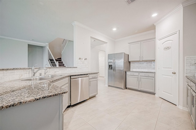 kitchen with sink, tasteful backsplash, stone countertops, light tile patterned flooring, and appliances with stainless steel finishes