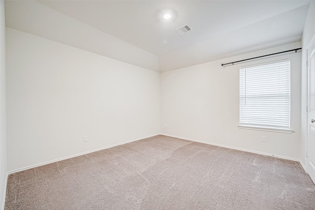 empty room with carpet and vaulted ceiling