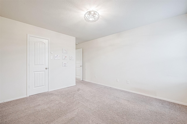 carpeted empty room with a textured ceiling