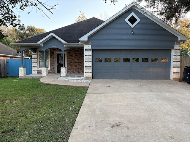 view of front of home with covered porch, a garage, and a front yard