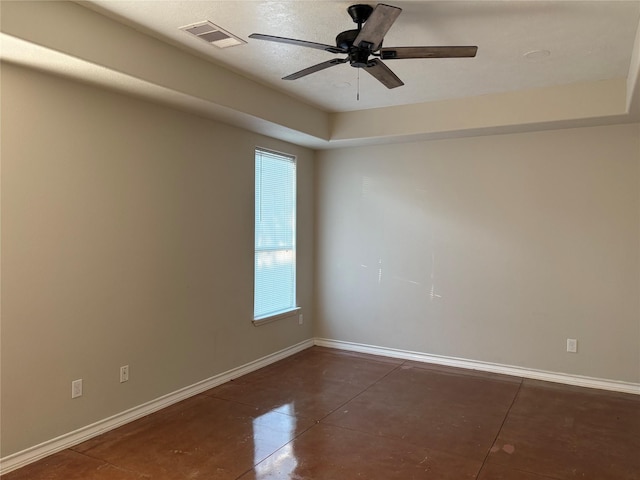 tiled empty room with a tray ceiling and ceiling fan