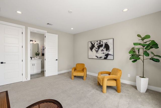 sitting room featuring light colored carpet