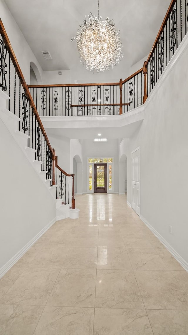 foyer with a high ceiling and a notable chandelier