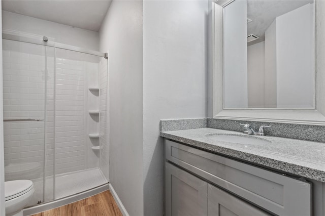 bathroom featuring hardwood / wood-style floors, vanity, toilet, and an enclosed shower