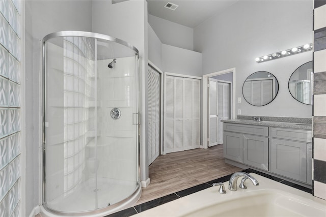 bathroom with hardwood / wood-style flooring, vanity, and walk in shower