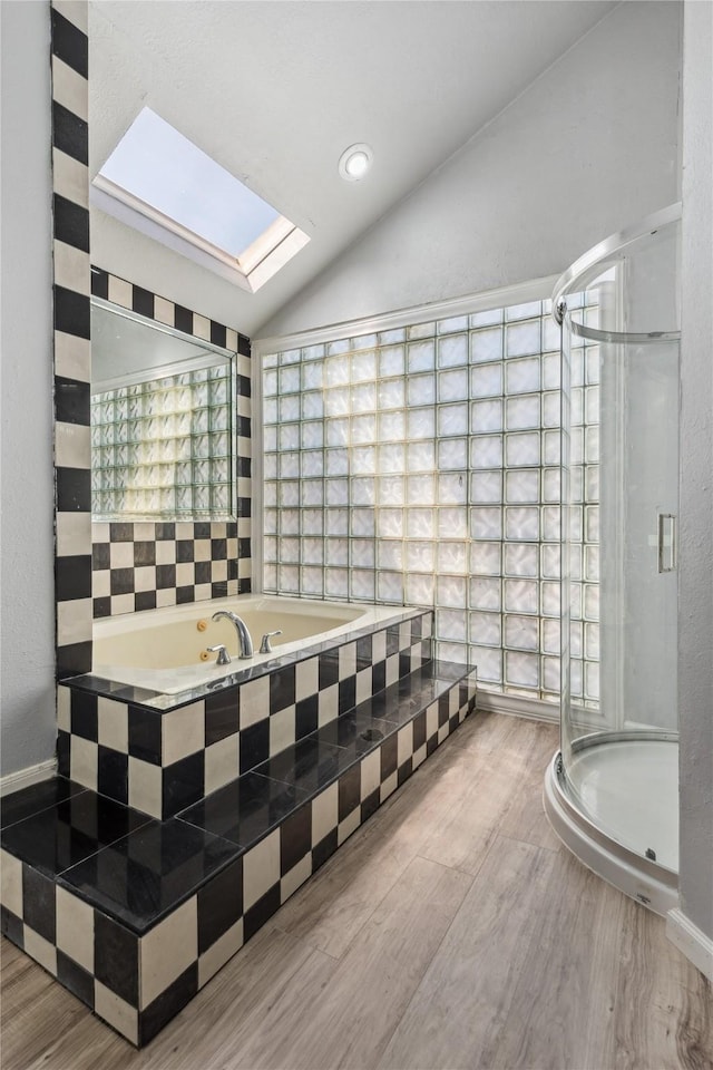 bathroom featuring vaulted ceiling with skylight and shower with separate bathtub