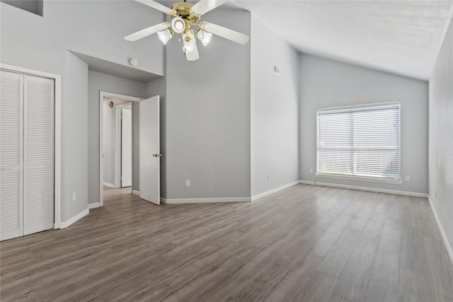 unfurnished living room with hardwood / wood-style flooring, ceiling fan, and high vaulted ceiling