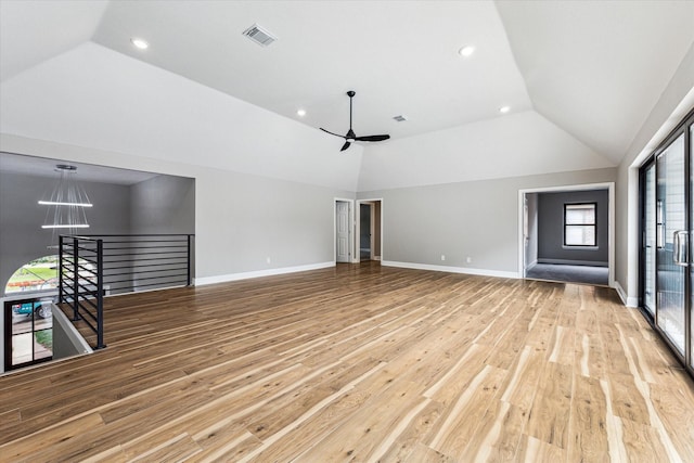 unfurnished living room with ceiling fan, a healthy amount of sunlight, lofted ceiling, and light hardwood / wood-style flooring