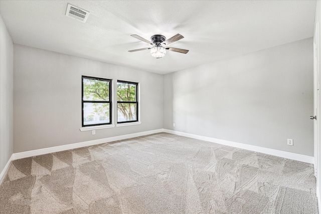 spare room featuring light carpet and ceiling fan