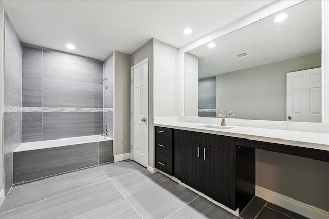 bathroom with vanity, tiled shower / bath combo, and tile patterned flooring