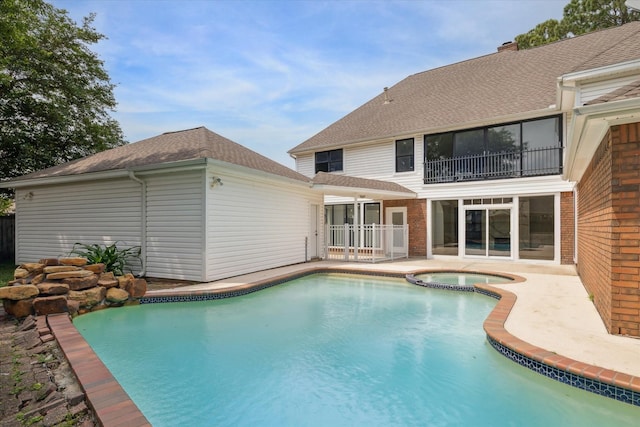 view of swimming pool featuring an in ground hot tub