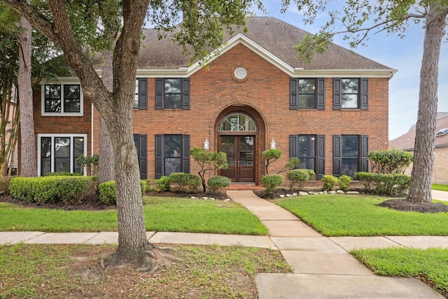 colonial-style house featuring a front yard