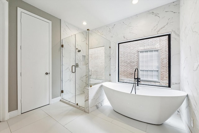 bathroom with tile walls and shower with separate bathtub