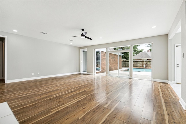 unfurnished living room with wood-type flooring and ceiling fan