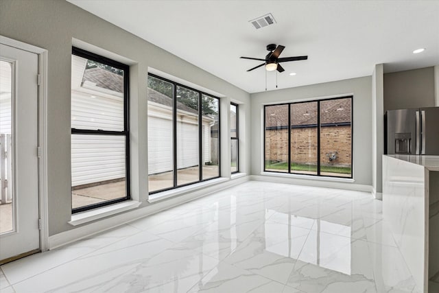 unfurnished sunroom featuring ceiling fan