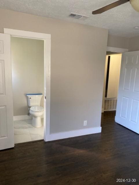 spare room with ceiling fan, dark hardwood / wood-style floors, and a textured ceiling