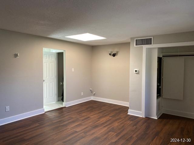 unfurnished room with dark hardwood / wood-style floors