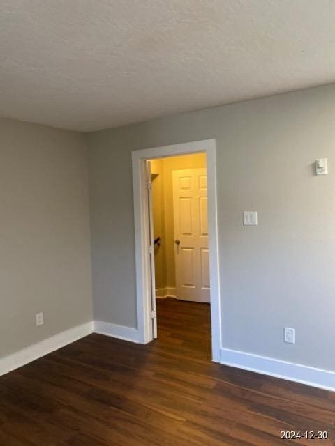 spare room featuring dark wood-type flooring